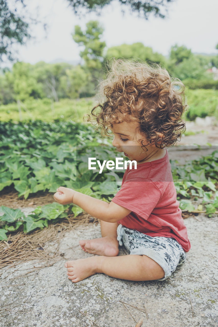 Girl looking away while plants outdoors