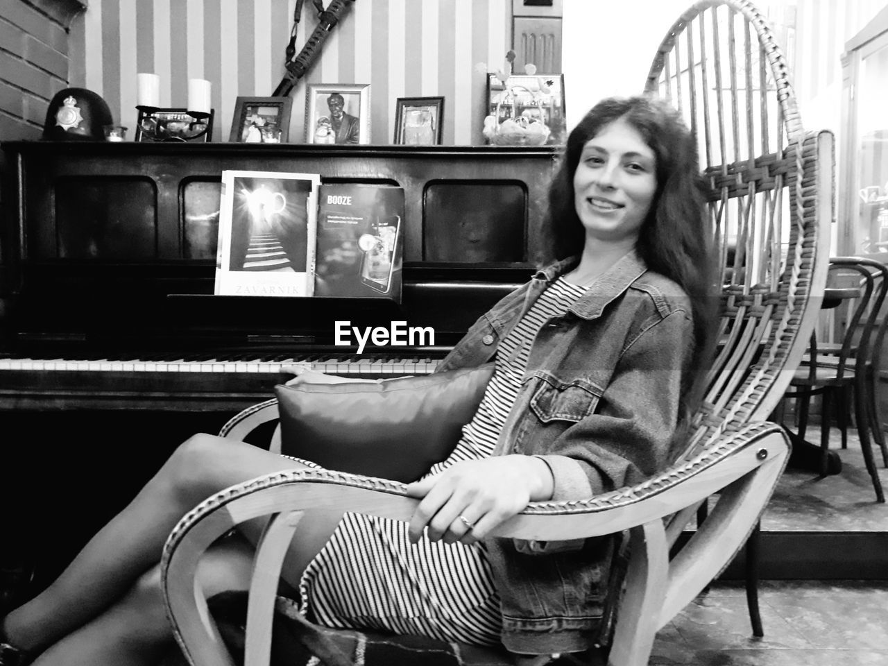 PORTRAIT OF SMILING YOUNG WOMAN SITTING ON CHAIR IN OFFICE