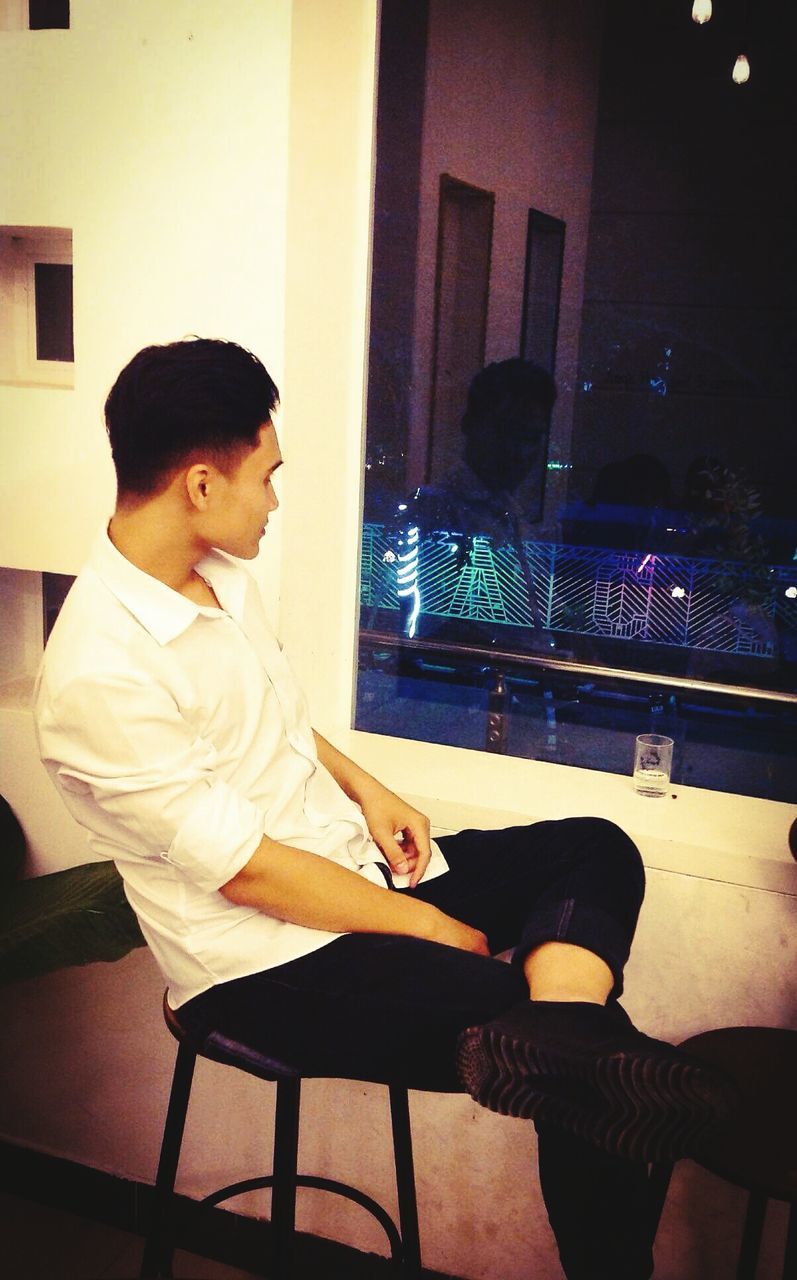 MAN SITTING ON SOFA
