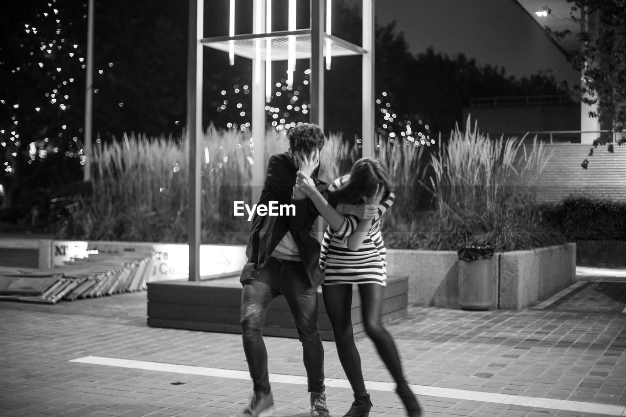 Man and woman covering face with hands