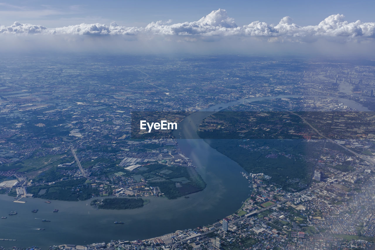 Aerial view of cityscape and mountains against sky