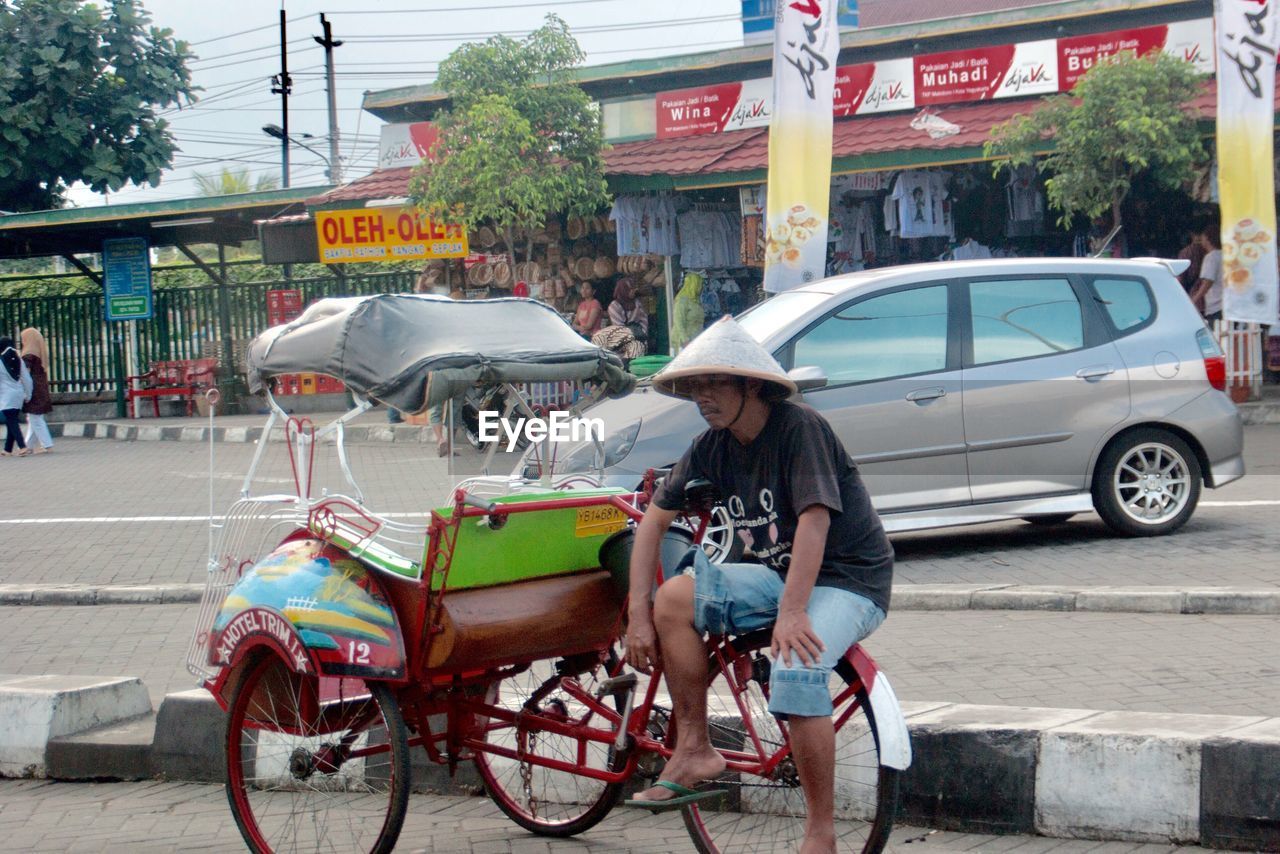 WOMAN WITH BICYCLE IN RAIN