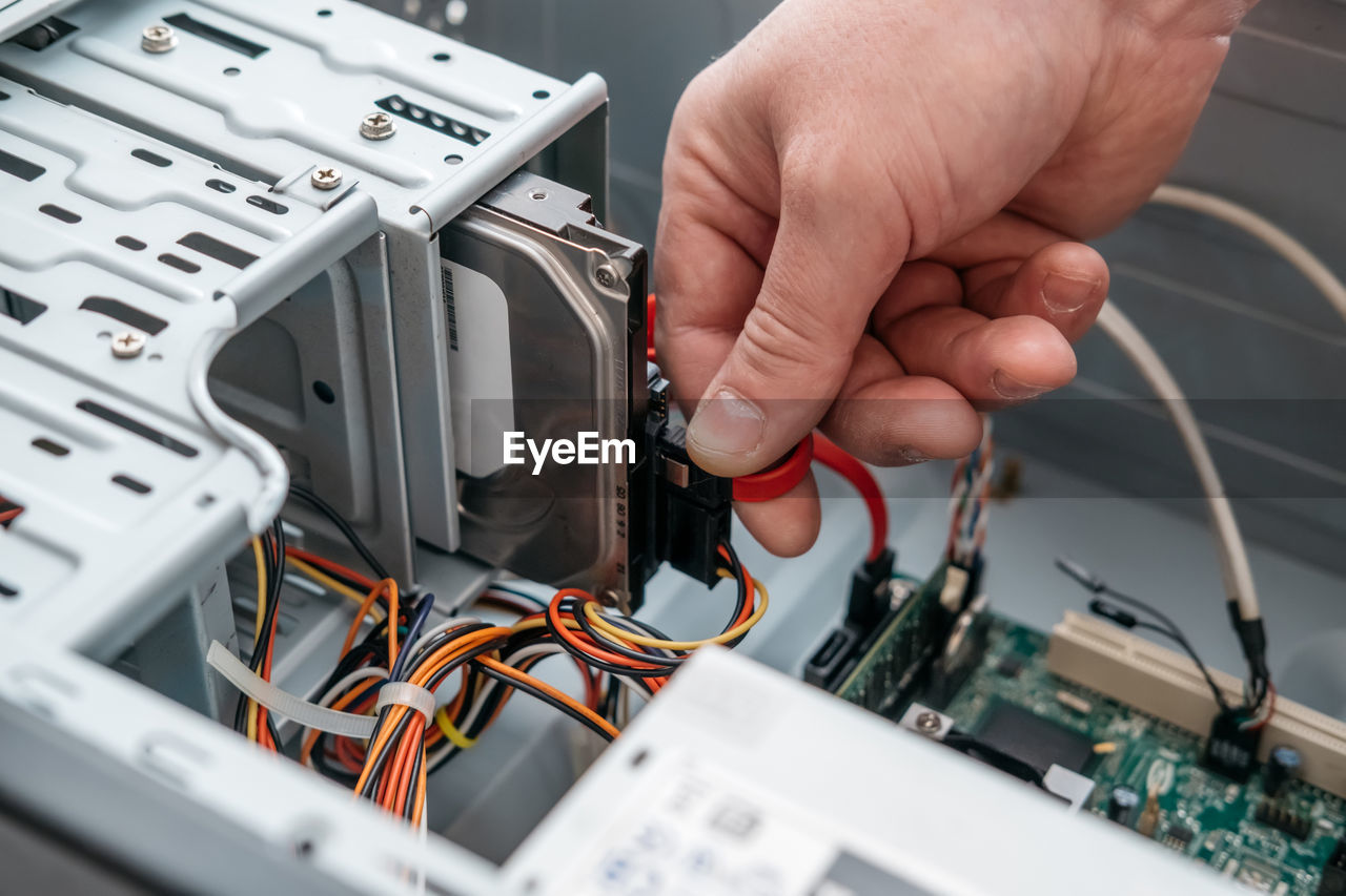 Cropped hands of person repairing cpu in workshop