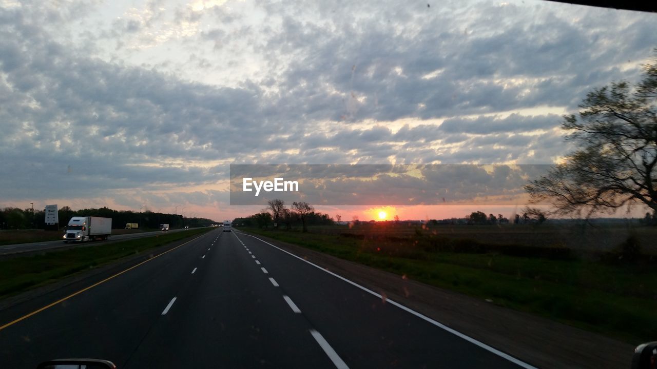 ROAD AMIDST LANDSCAPE AGAINST SKY DURING SUNSET