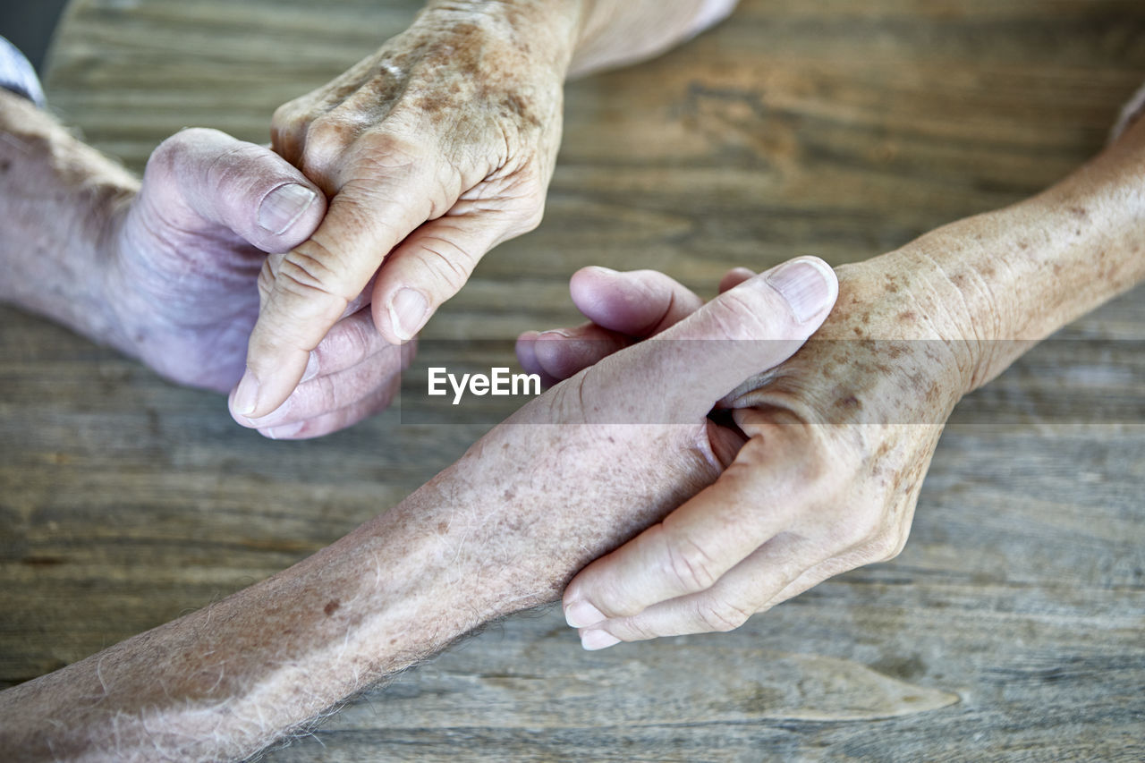 Senior couple holding hands, close-up