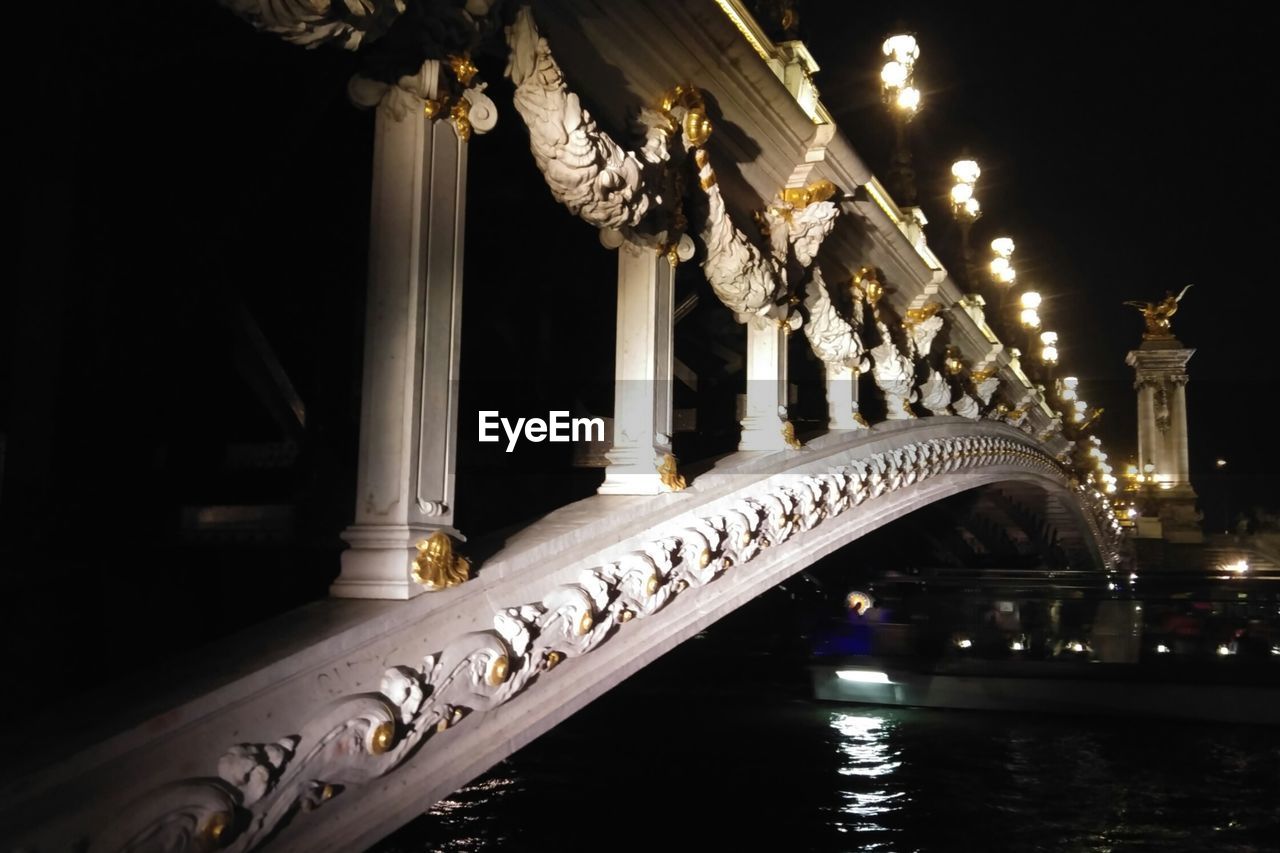 LOW ANGLE VIEW OF ILLUMINATED BRIDGE