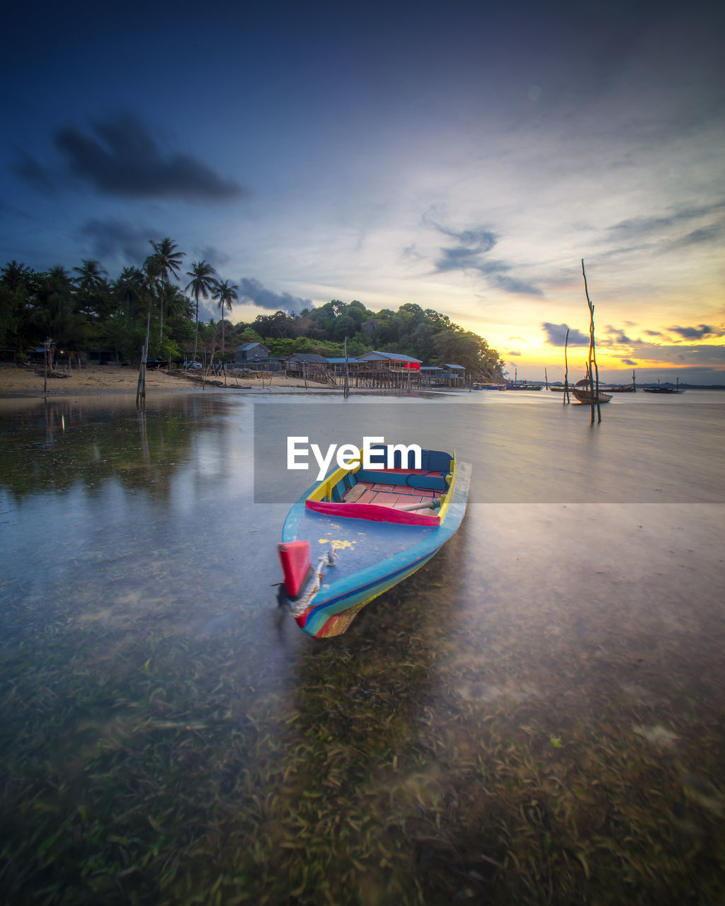 Boats in lake against sky during sunset