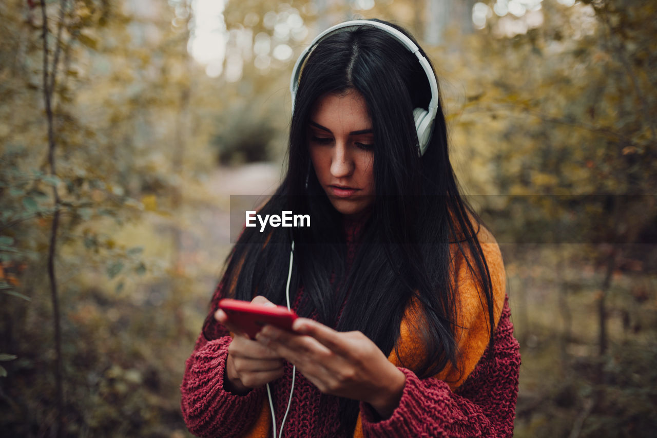 Close-up of young woman using smart phone in forest