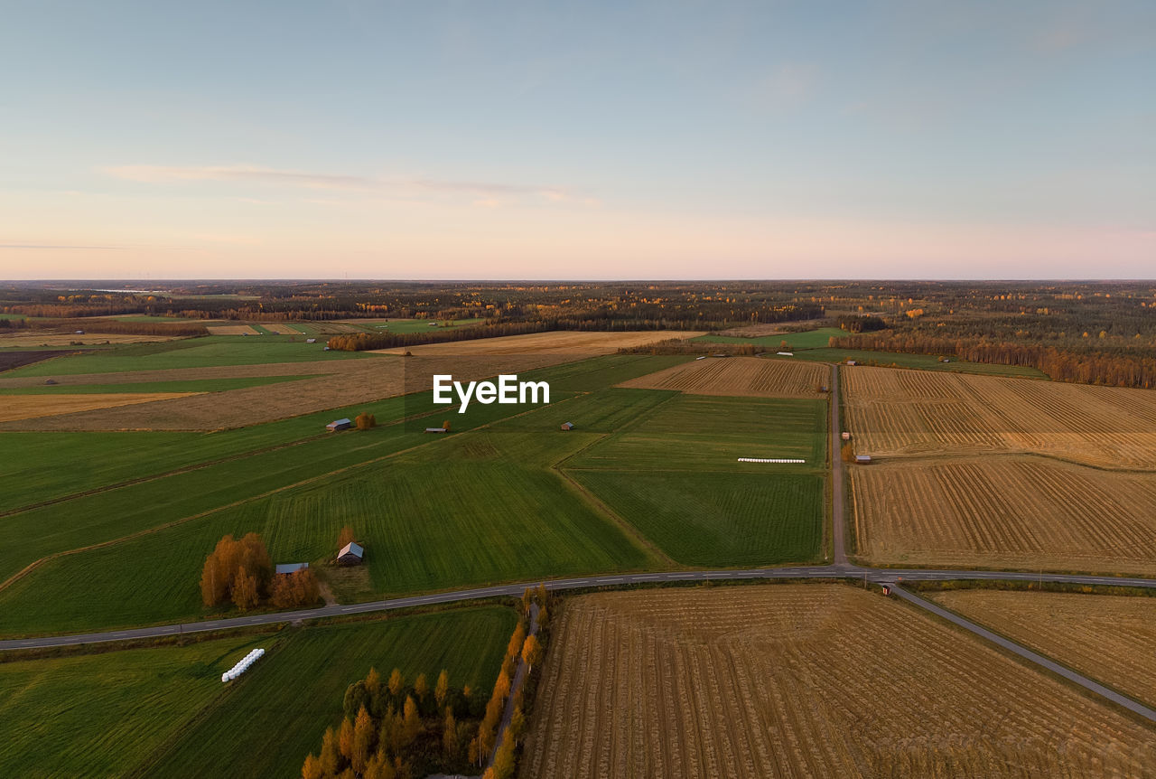 The country roads cross the autumn fields at the northern finland. 