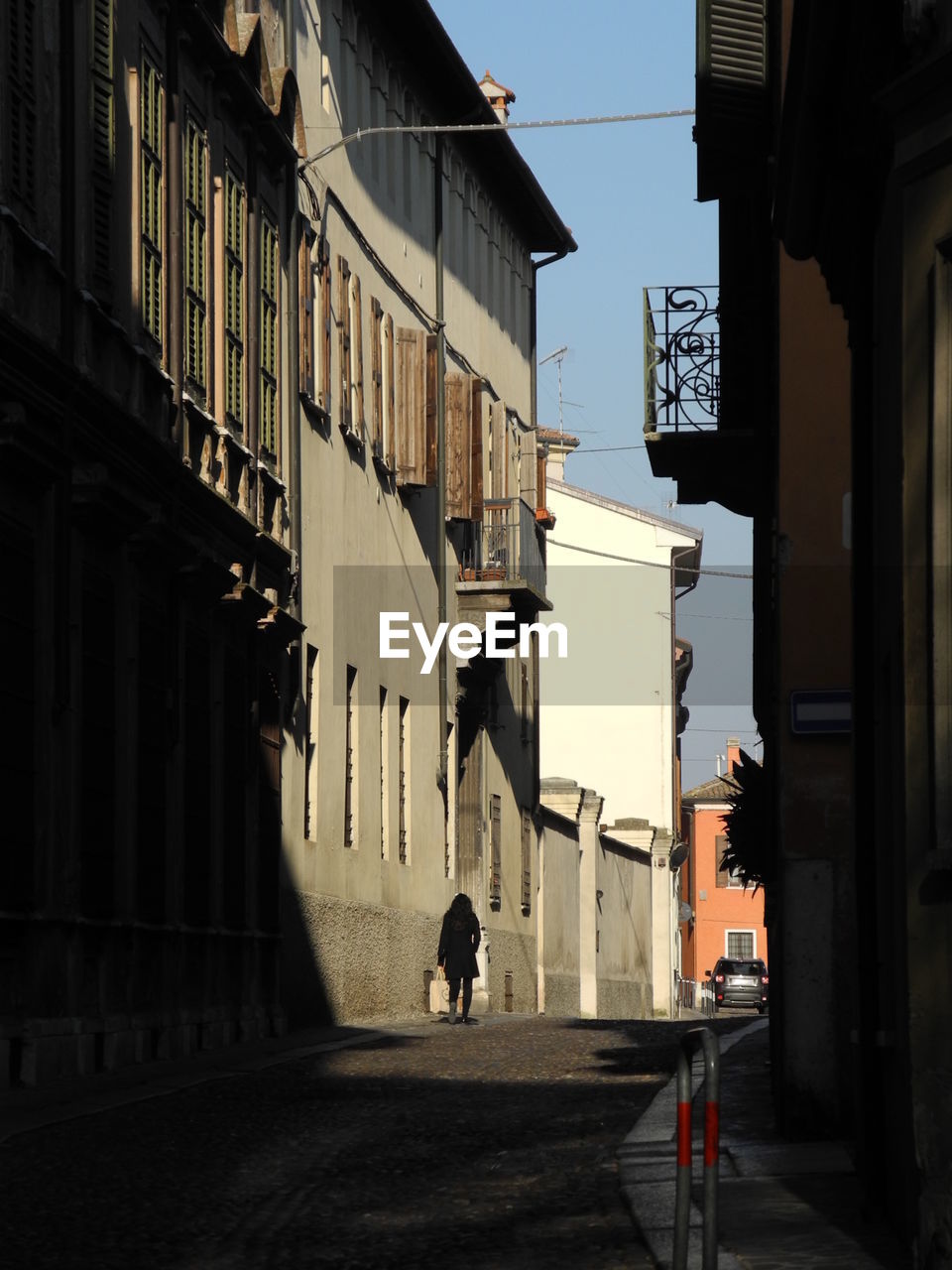 PEOPLE WALKING ON STREET AMIDST BUILDINGS