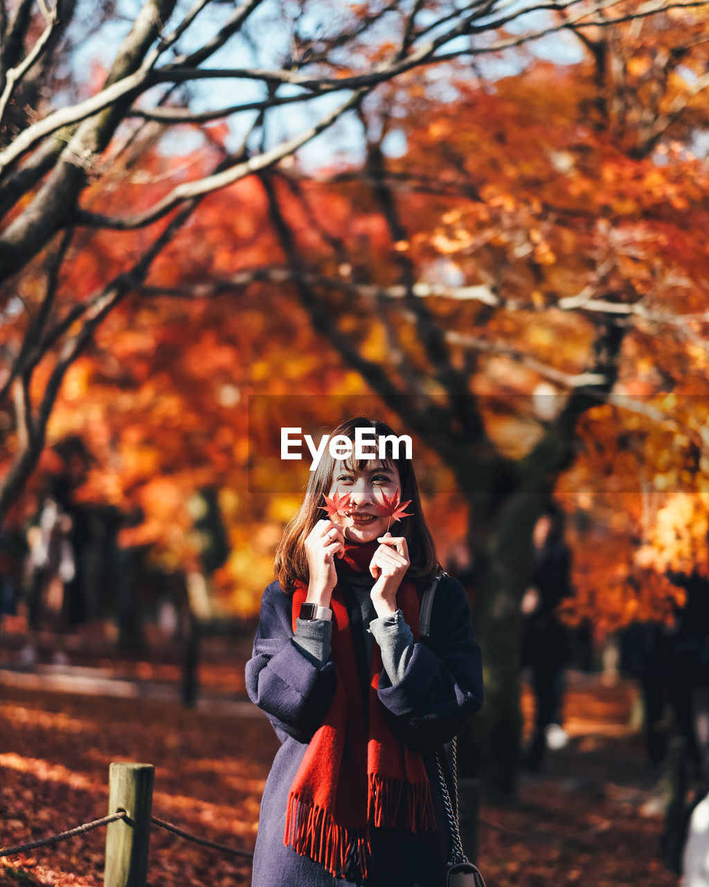 Young woman holding leaves during autumn