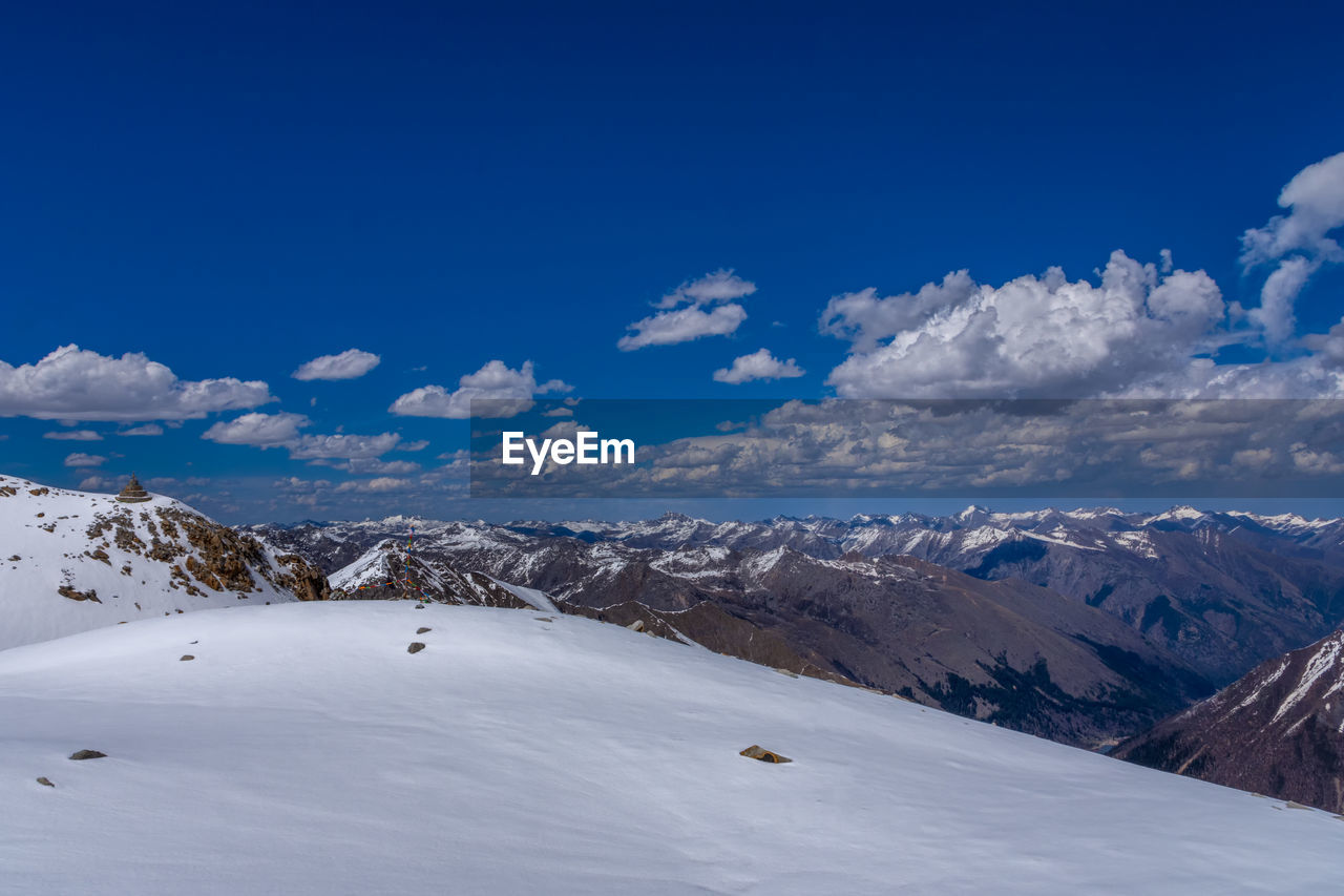 SNOW COVERED LANDSCAPE AGAINST BLUE SKY