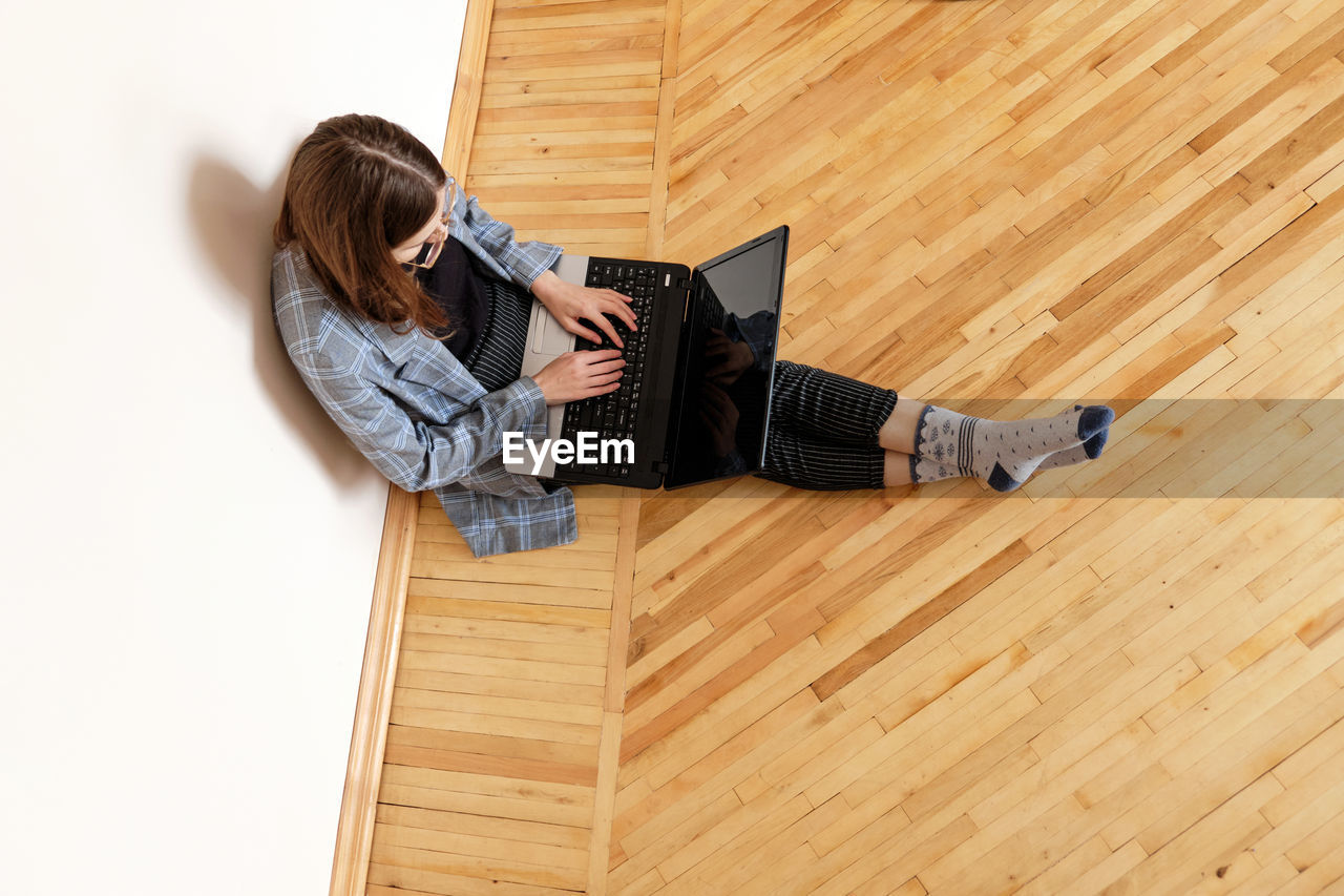 Young woman in a suit working at home at the computer at his workplace