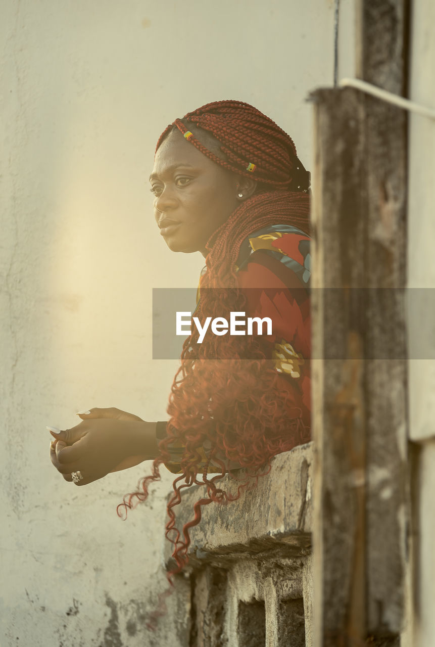 African woman looking out over the sea from a balcony at sunset in accra ghana west africa