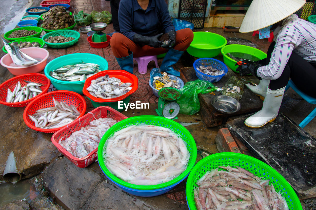 HIGH ANGLE VIEW OF PEOPLE AT MARKET STALL