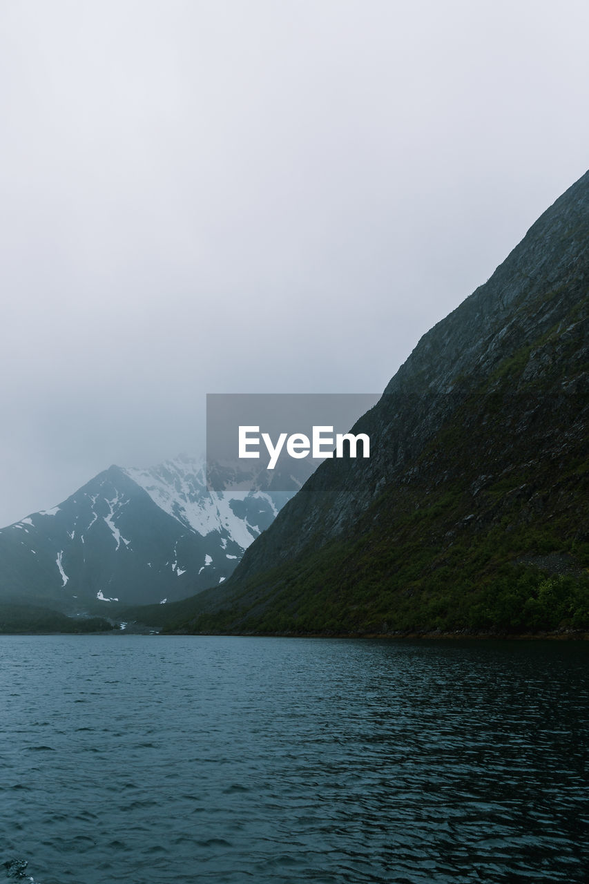 SCENIC VIEW OF LAKE AND SNOWCAPPED MOUNTAINS AGAINST SKY