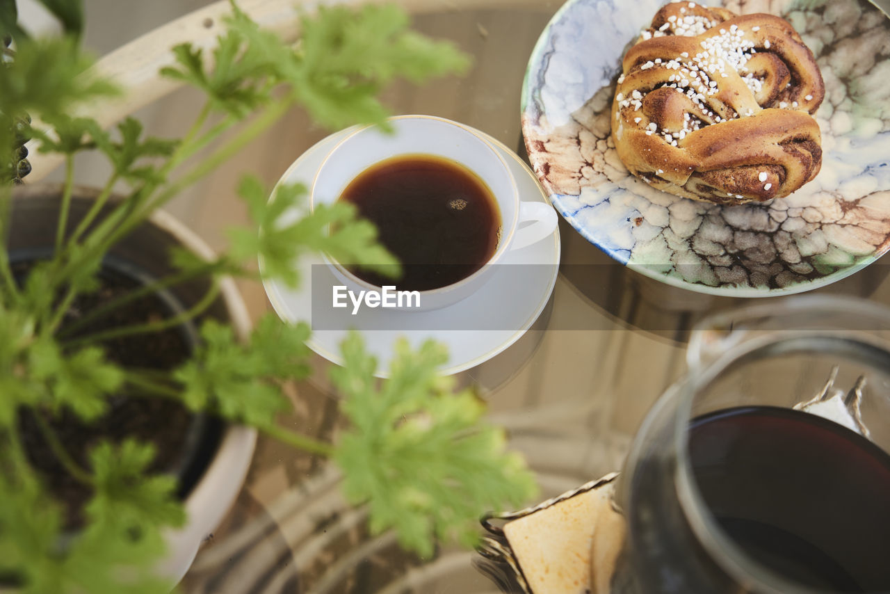 Cup of tea and cinnamon bun on table