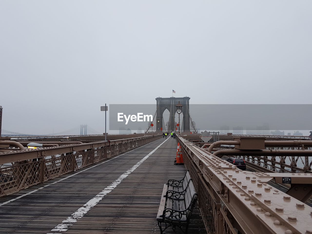 Brooklyn bridge against clear sky during foggy weather