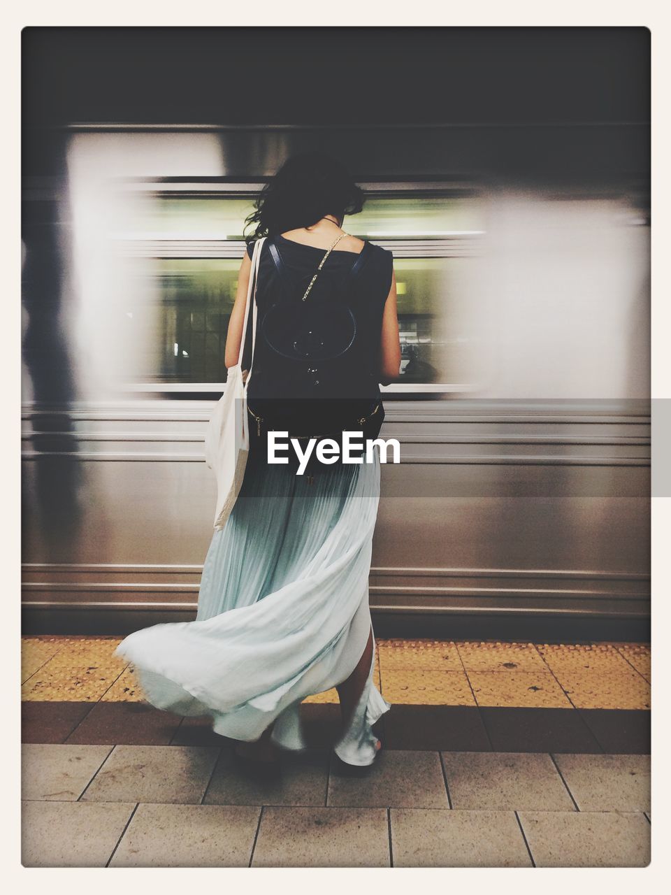 Rear view of woman standing on railway station