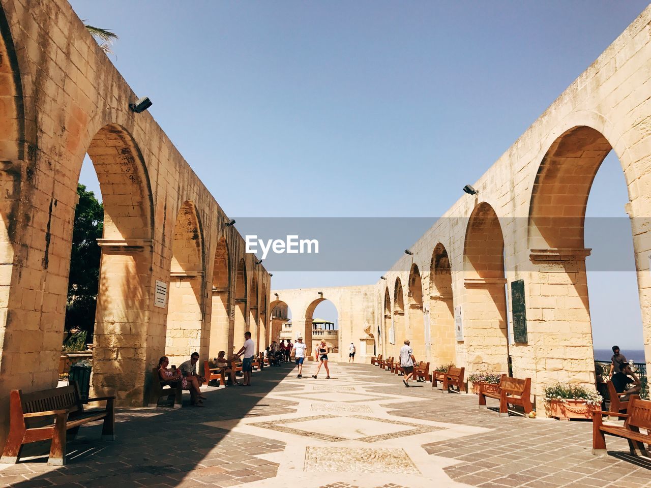 PEOPLE WALKING IN FRONT OF HISTORICAL BUILDING AGAINST SKY