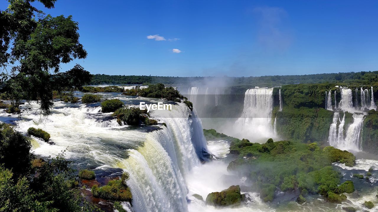 PANORAMIC VIEW OF WATERFALL AGAINST SKY