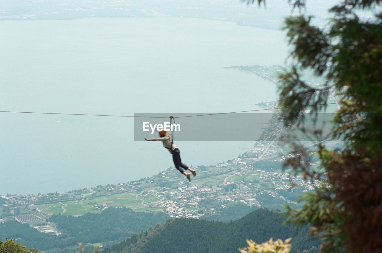 Full length of woman hanging on rope