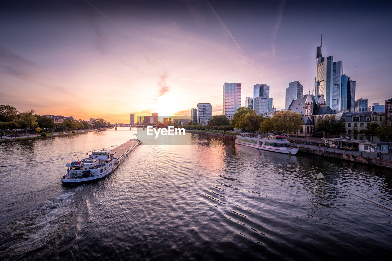 Frankfurt am main, germany, container ship on the main at sunset with the sklyine in the background 