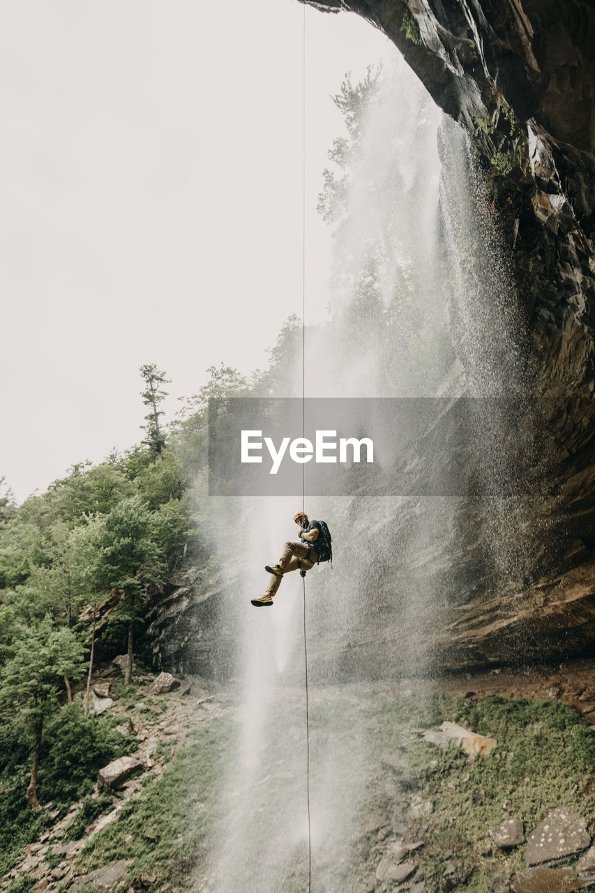 A man rappels a waterfall in the catskills, new york, new england