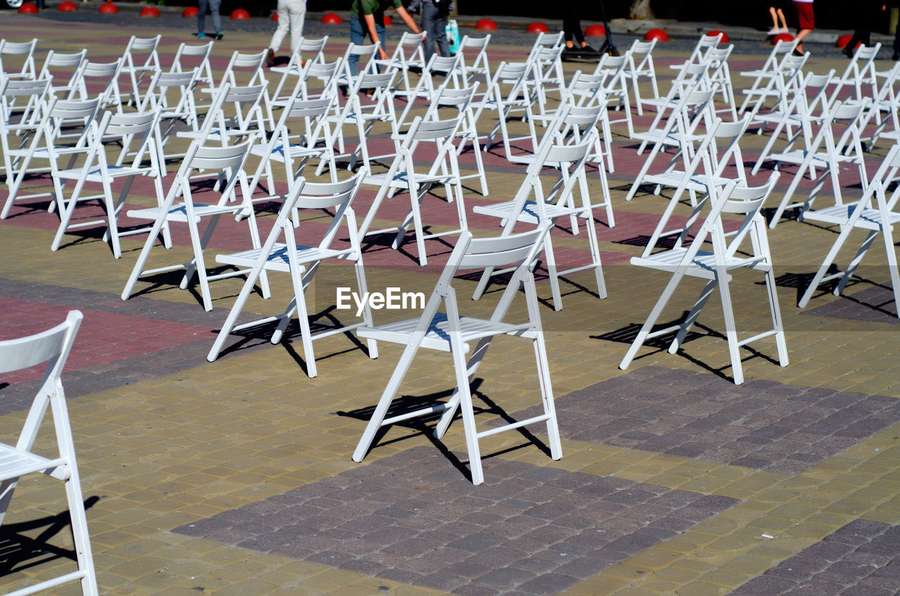 Folding chairs are arranged on recreation area. empty folding wooden chairs in a public square 