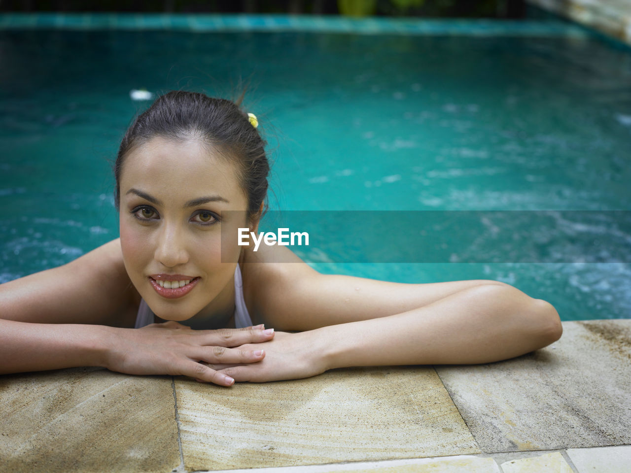 Portrait of young woman in swimming pool at tourist resort