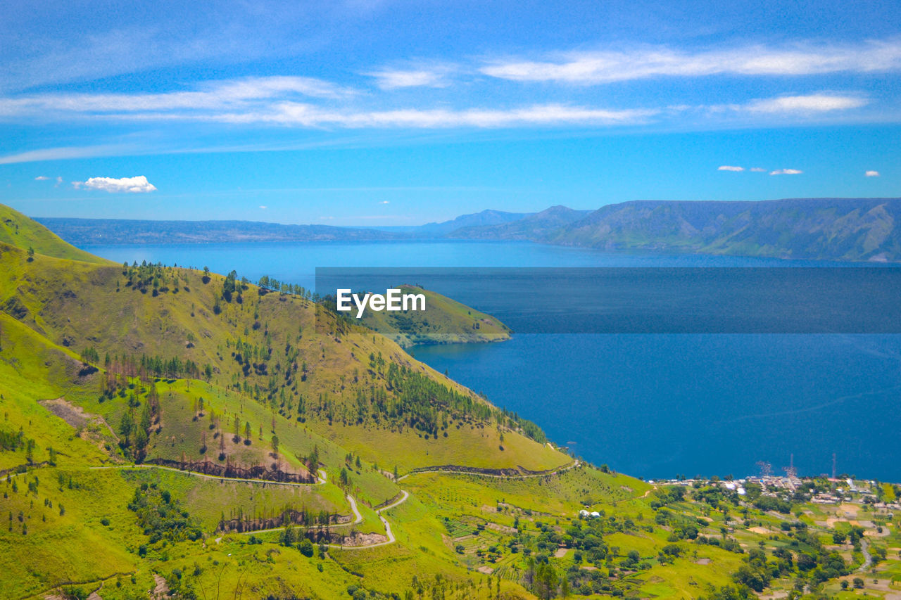 Scenic view of sea and mountains against sky