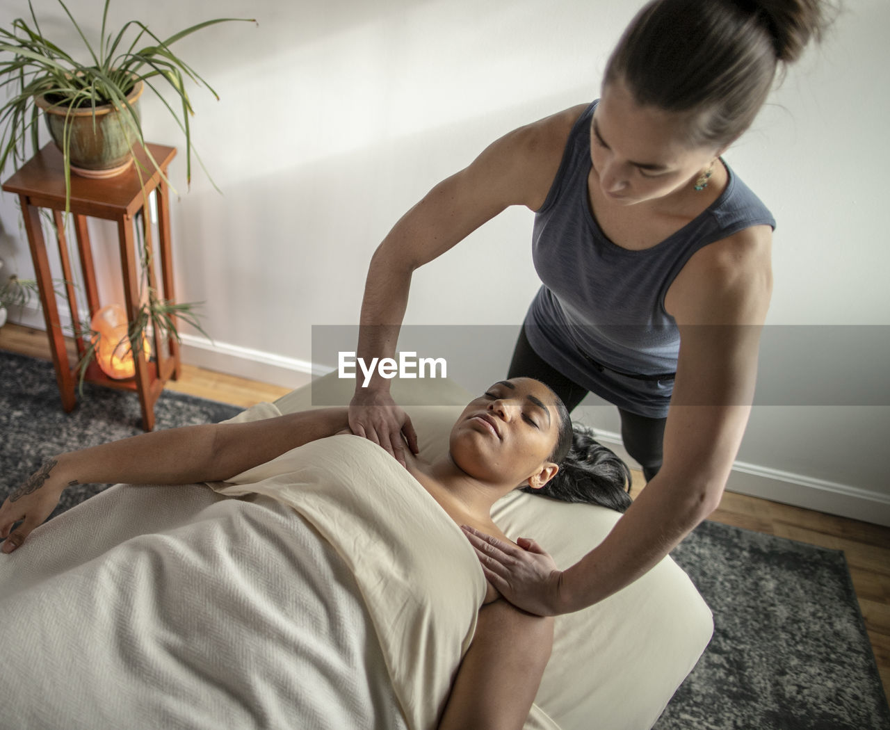 Female massage therapist concentrates on her patient's shoulders