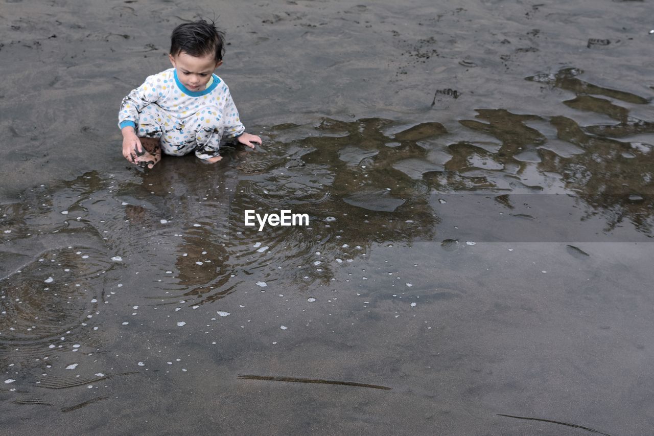 High angle view of boy sitting at beach