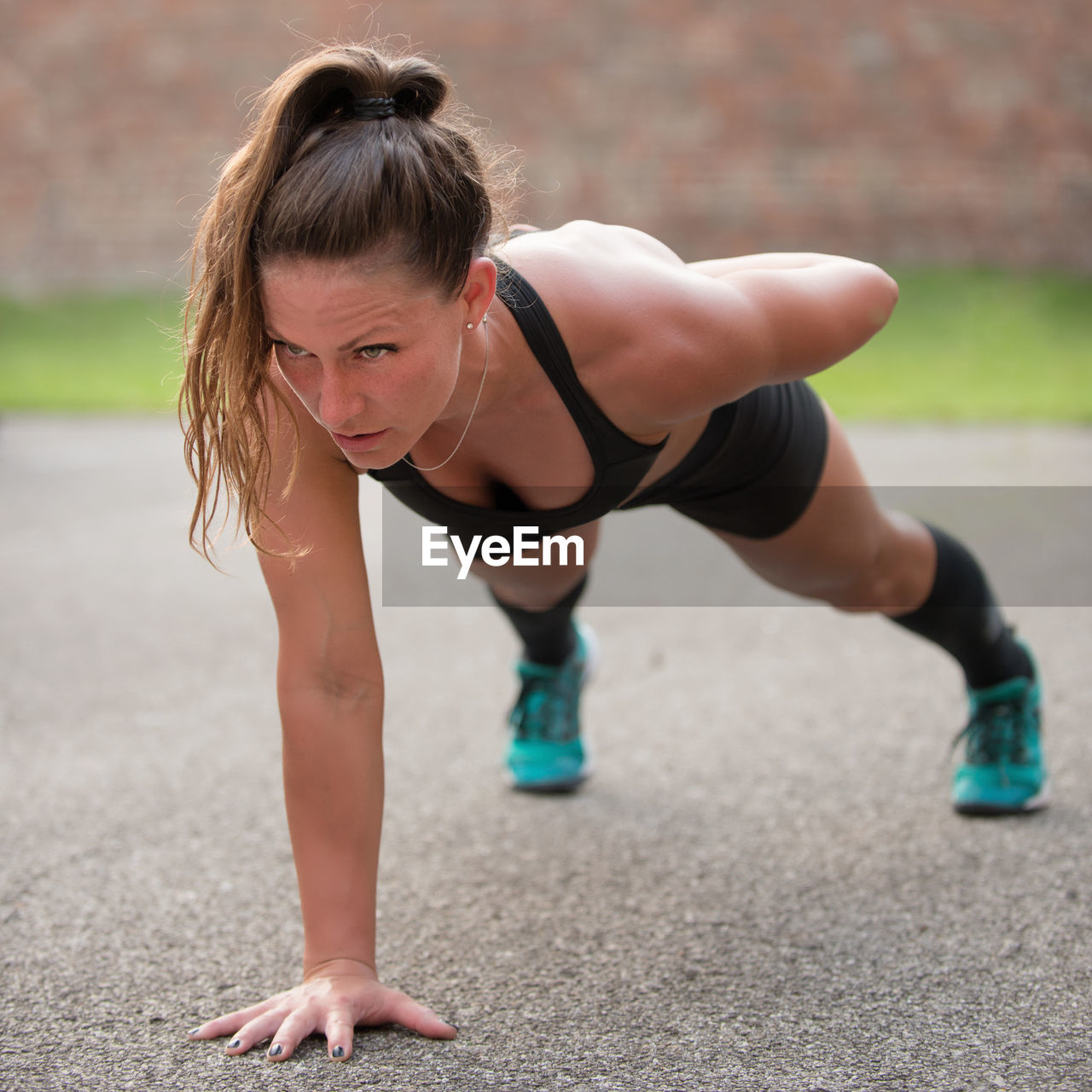 Mid adult woman doing push-ups on road