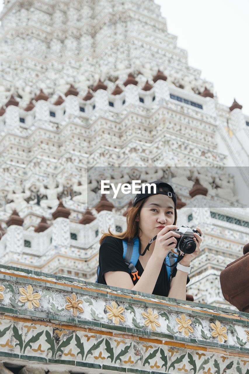 PORTRAIT OF BEAUTIFUL YOUNG WOMAN IN TEMPLE