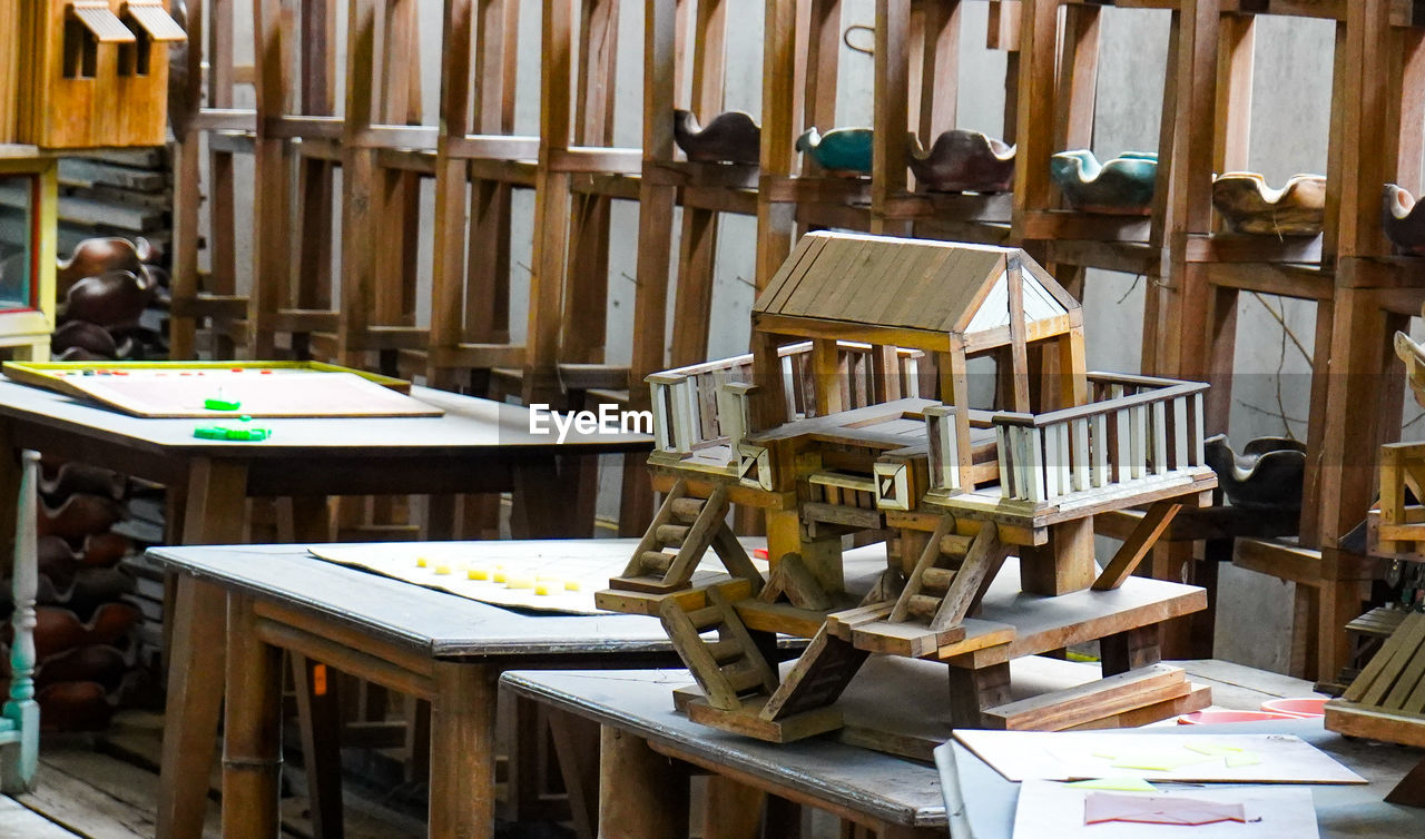 wood, table, indoors, library, no people, seat, furniture, chair, book, business, large group of objects, room, workshop, education, publication