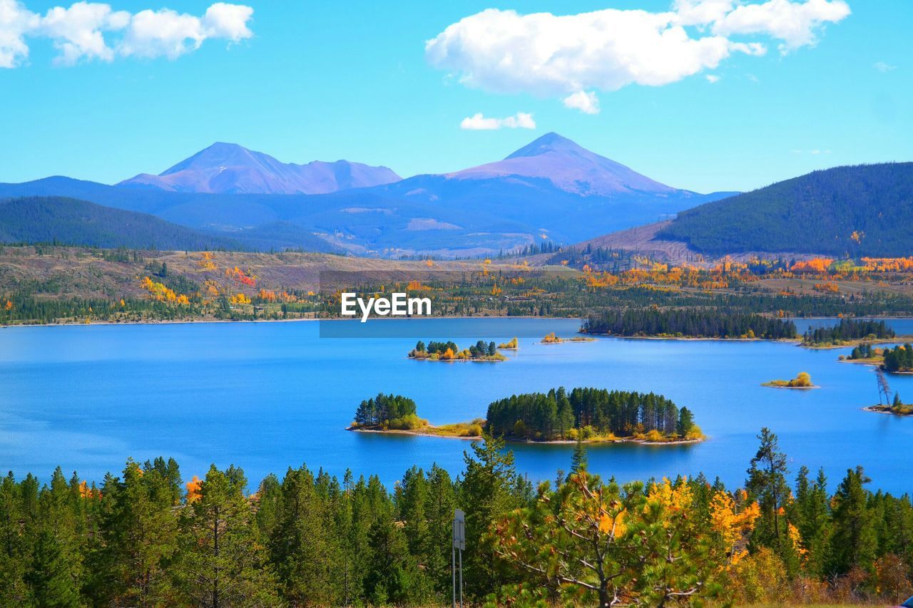 Scenic view of lake by mountains against sky