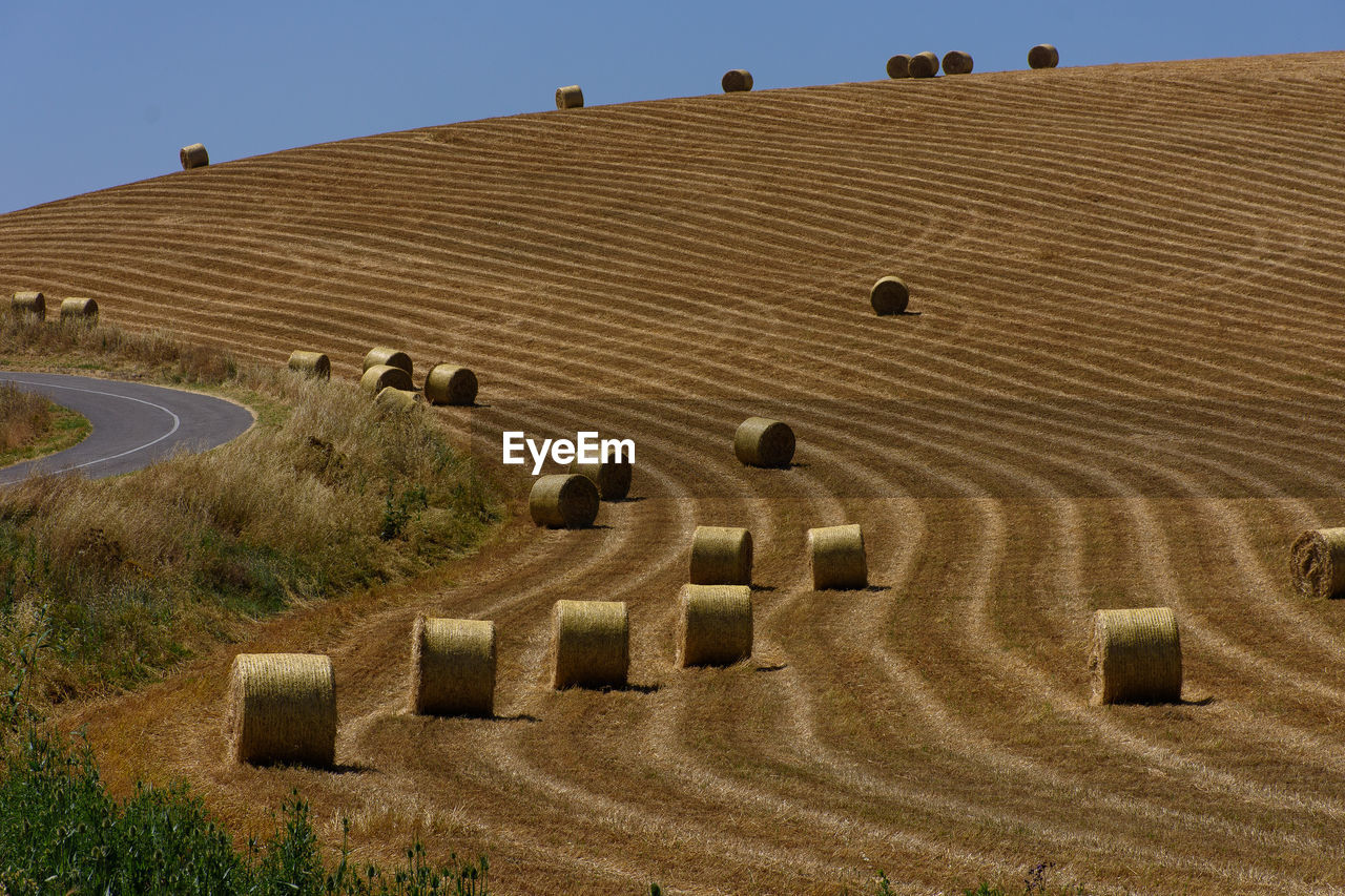 High angle view of hay bales on field against sky