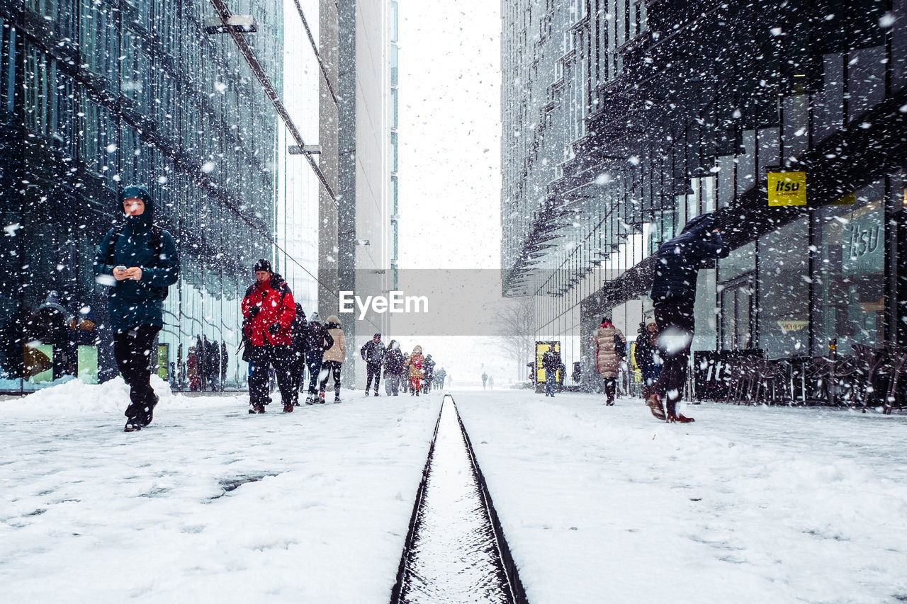 PEOPLE ON SNOW COVERED CITY