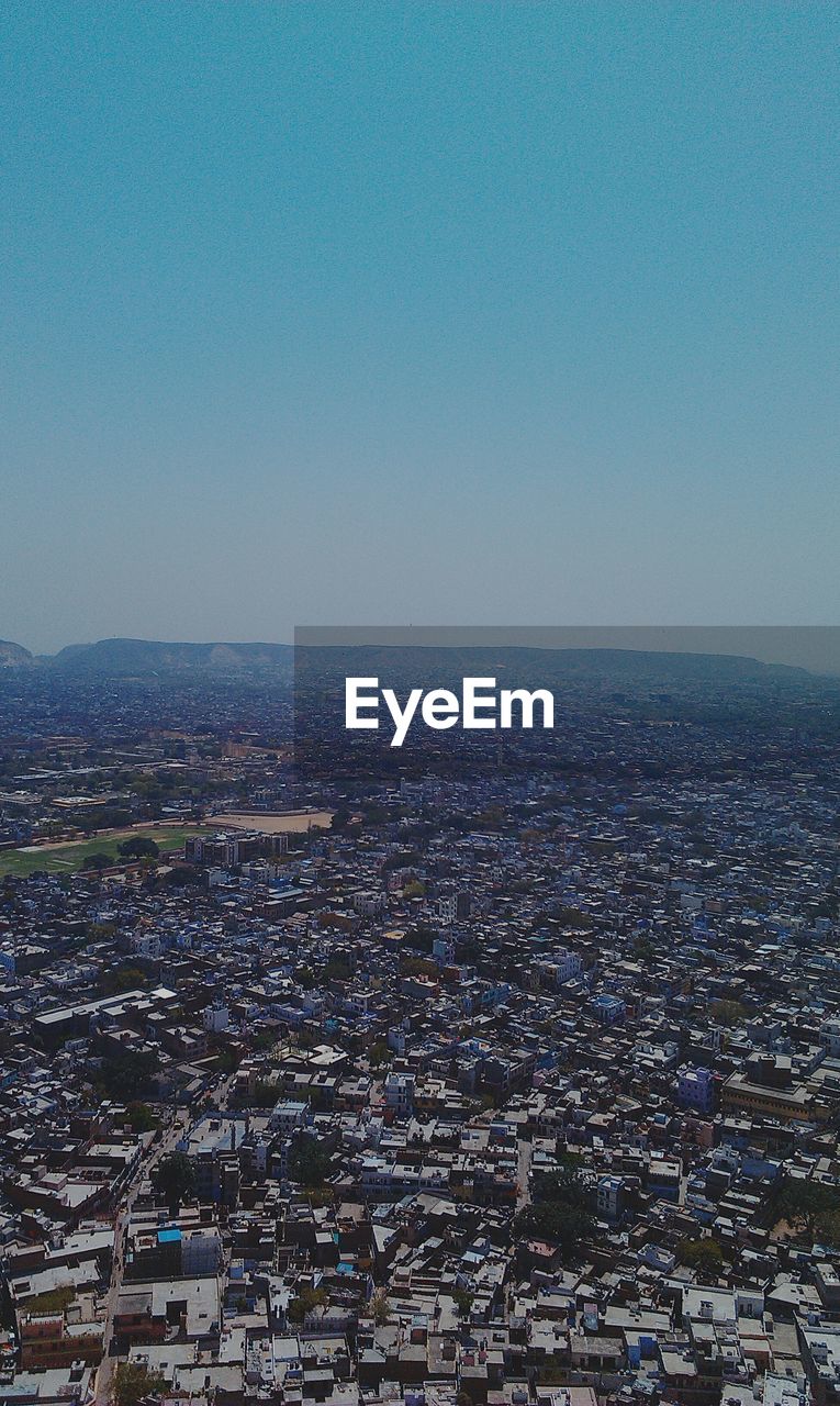 AERIAL VIEW OF CITYSCAPE AGAINST BLUE SKY