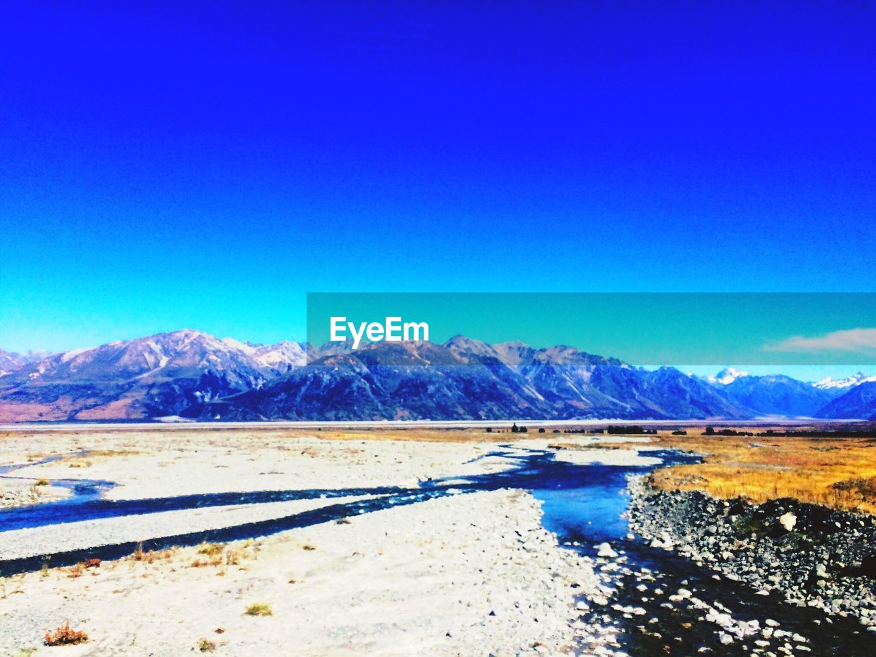 SCENIC VIEW OF SNOWCAPPED MOUNTAINS AGAINST BLUE SKY