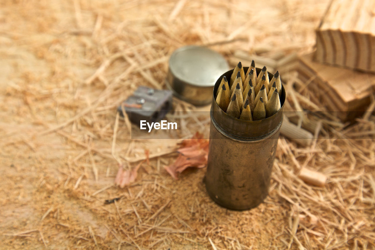High angle view of pencils in container on hay