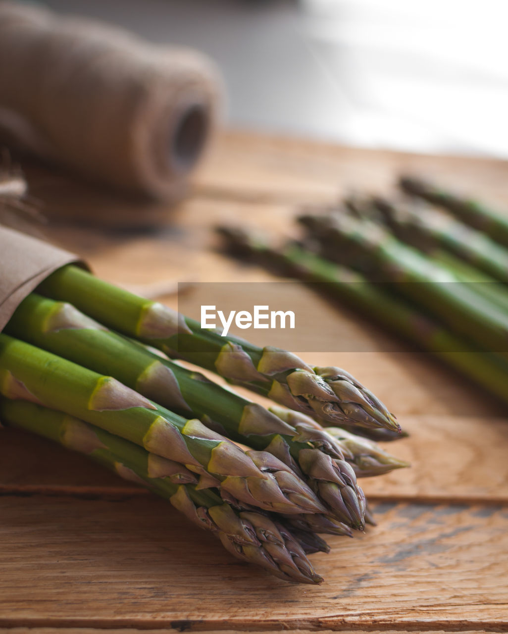 Close-up of fresh green asparagus on wooden background