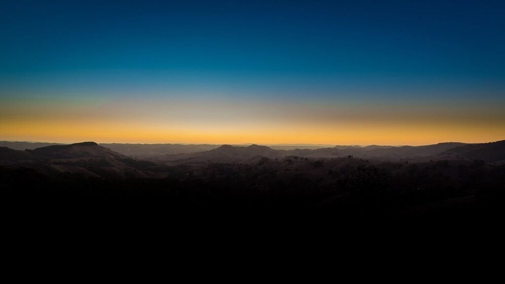 SCENIC VIEW OF MOUNTAINS AT SUNSET