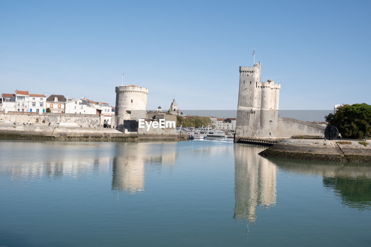 architecture, water, built structure, building exterior, reflection, sky, building, clear sky, travel destinations, history, nature, sea, the past, blue, travel, tower, city, no people, day, place of worship, landmark, tourism, sunny, religion, outdoors, waterfront, waterway, old, copy space, château