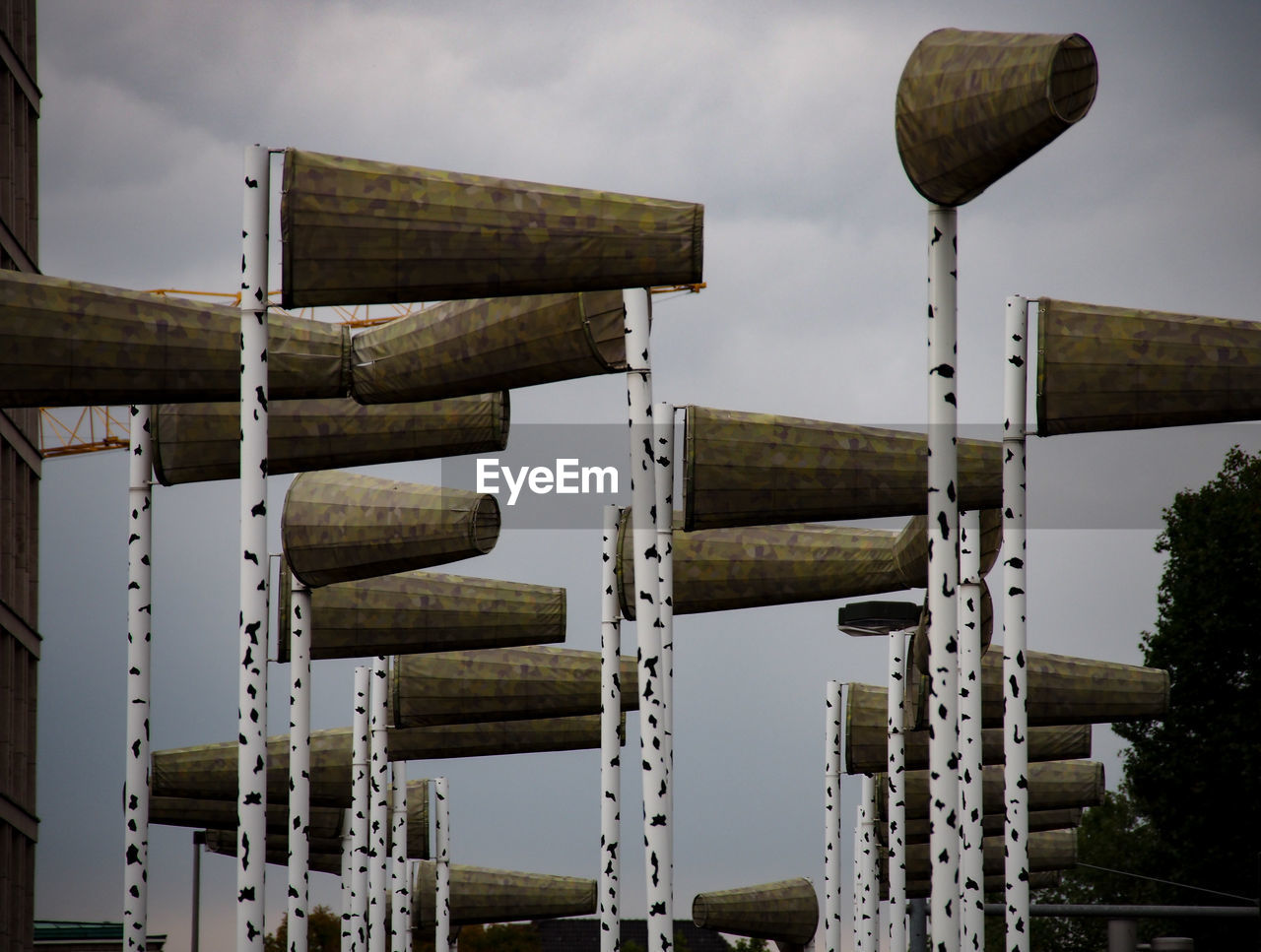 LOW ANGLE VIEW OF WOODEN POSTS AGAINST SKY