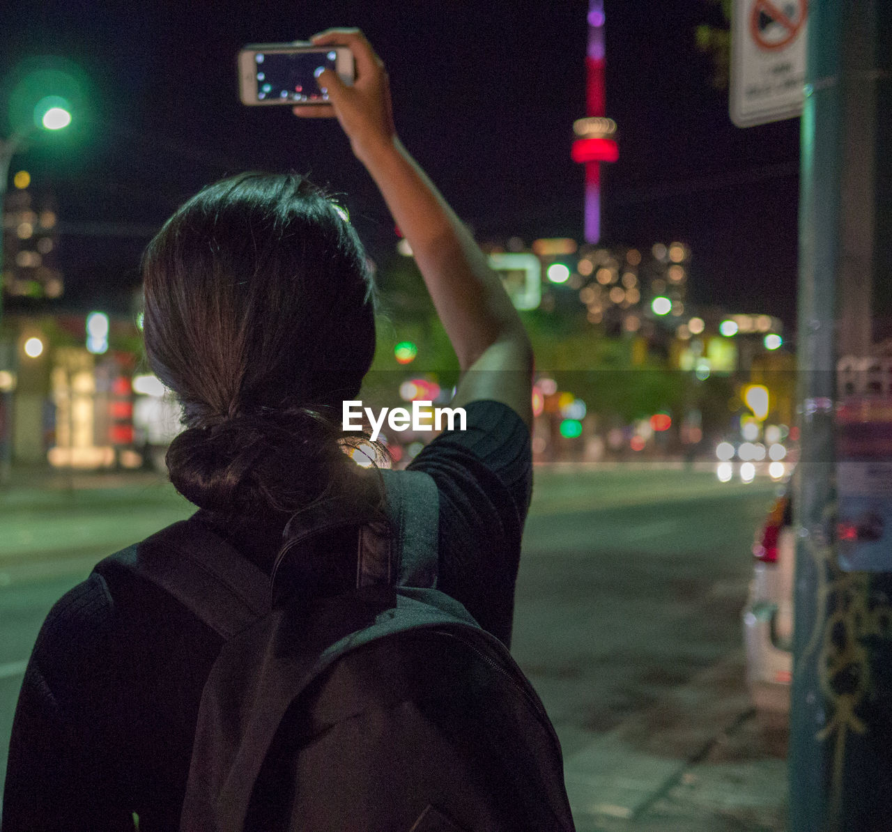 REAR VIEW OF MAN PHOTOGRAPHING ILLUMINATED CITYSCAPE