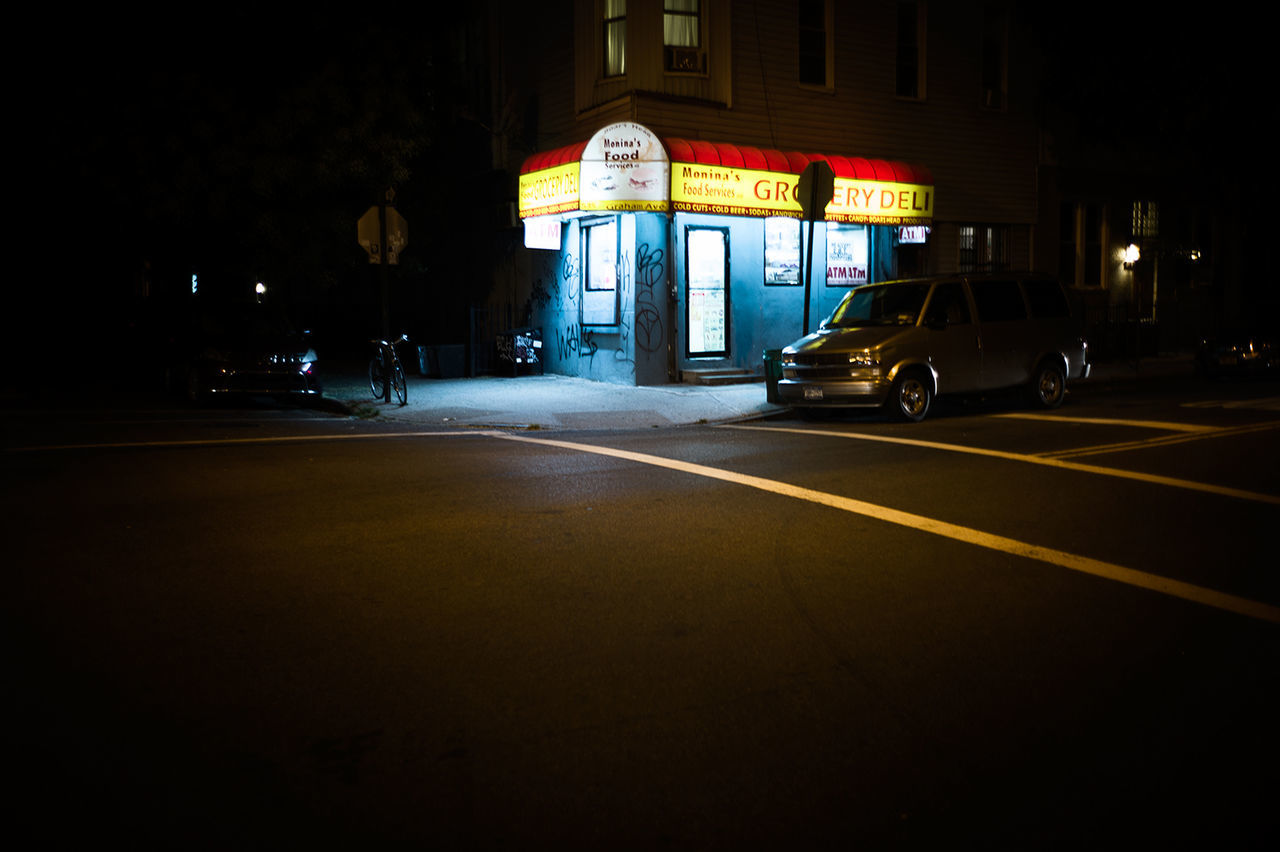 ILLUMINATED ROAD IN CITY AT NIGHT