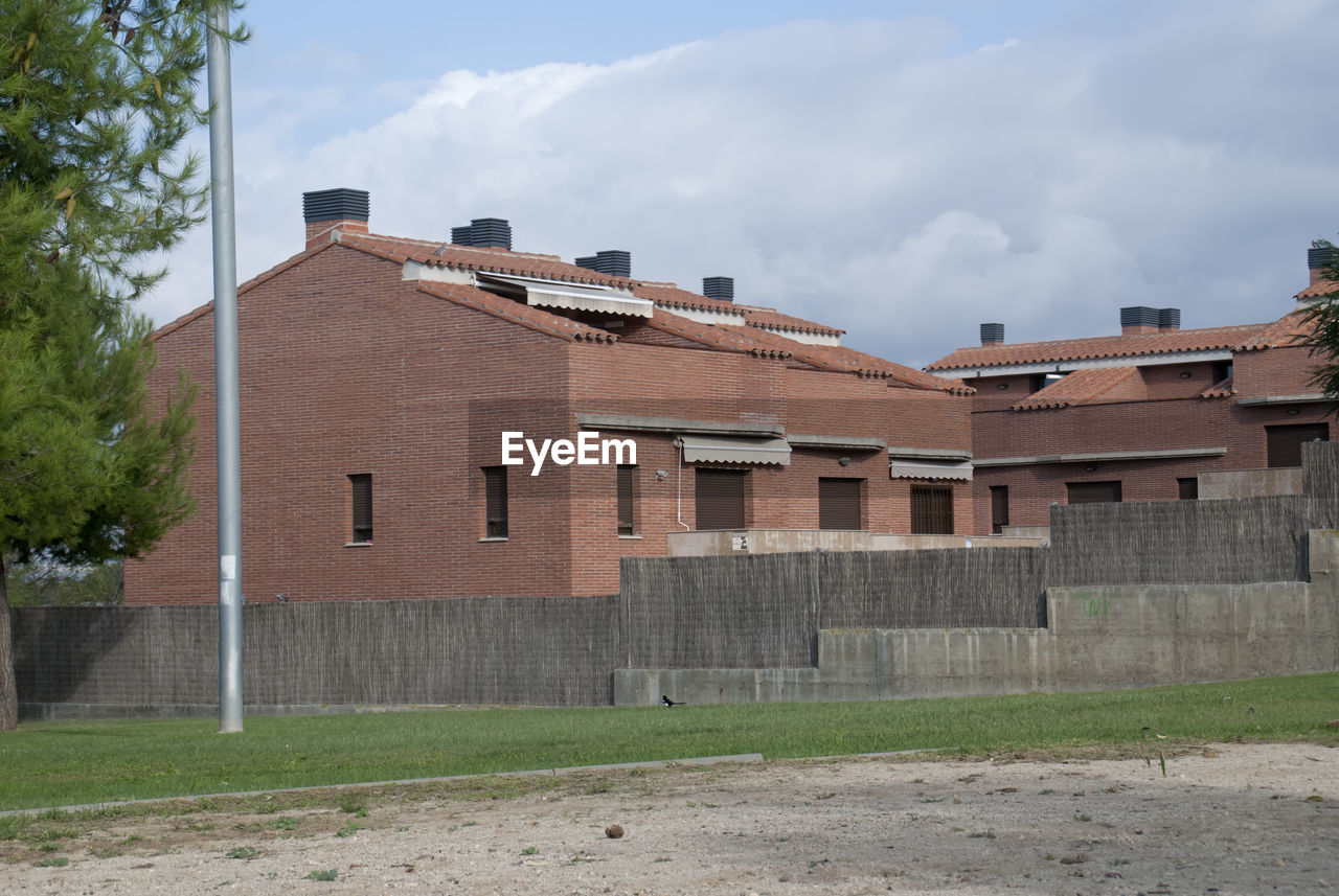 HOUSES ON FIELD AGAINST BUILDINGS