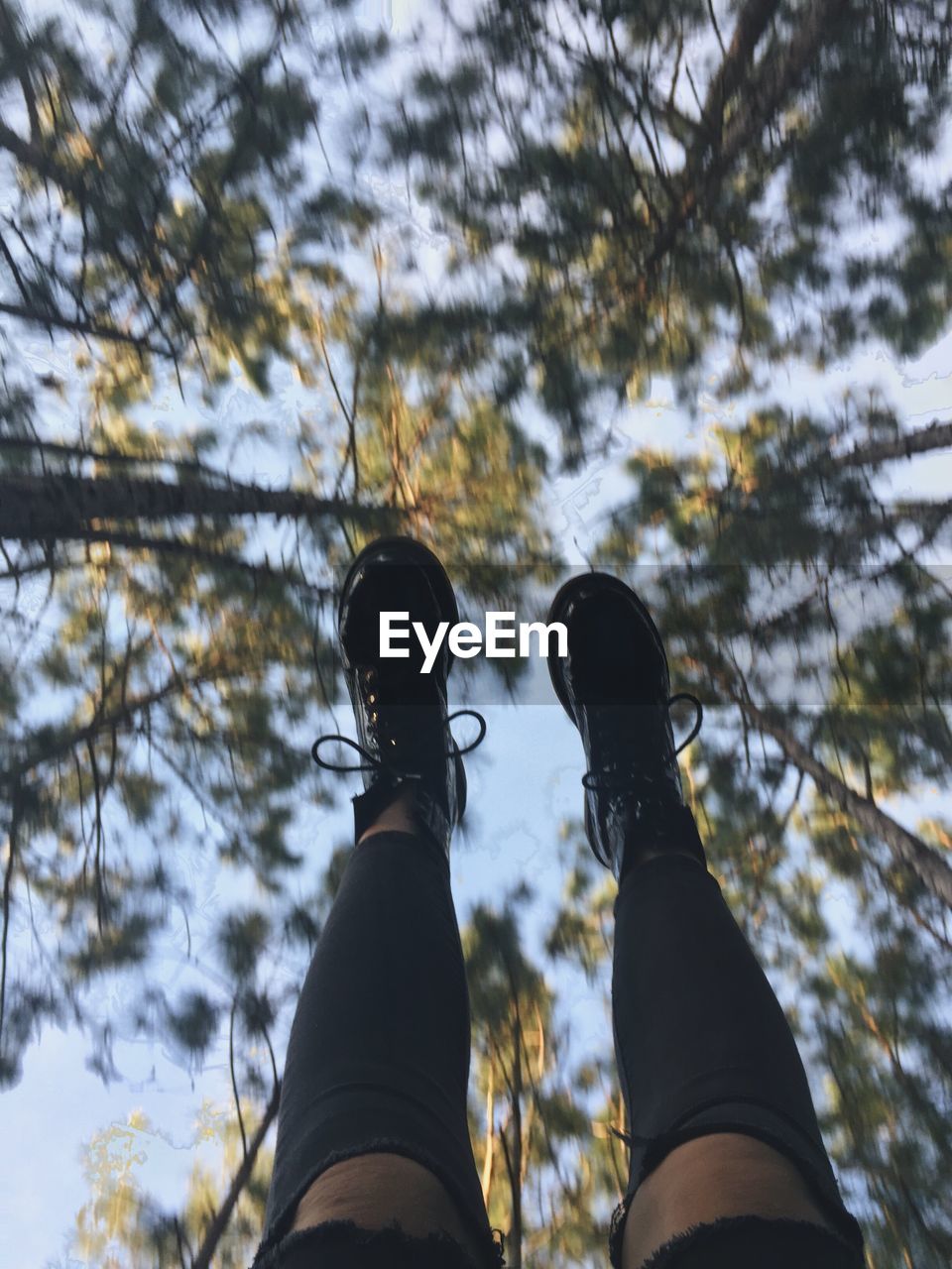 Low angle view of human feet against clear sky